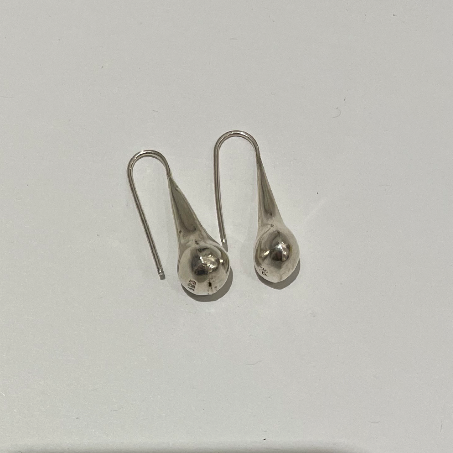 The earrings on a white surface.