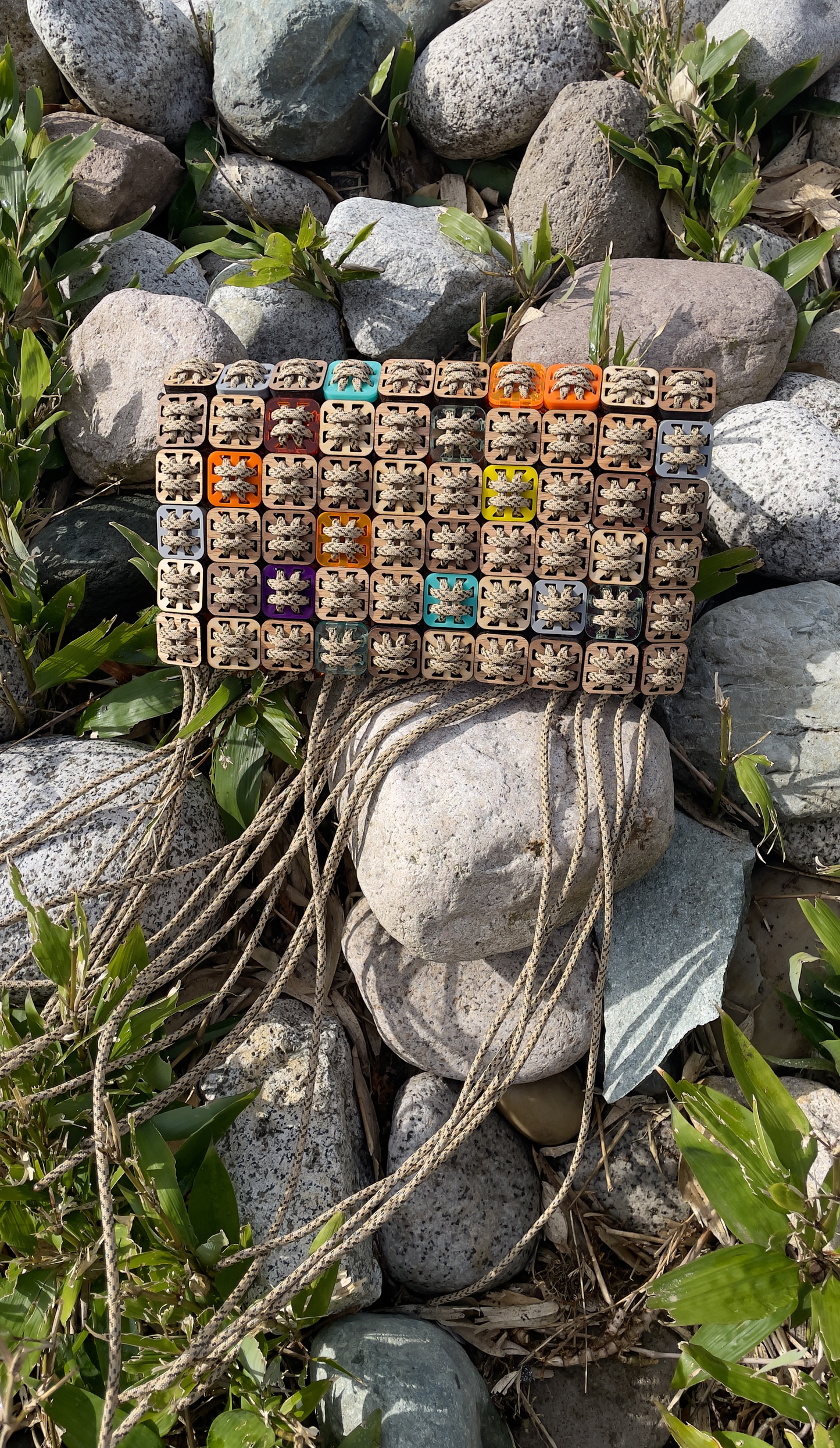 Handcrafted pixel clutch in laser-cut wood, acrylic, and cord by Studio Jazbi