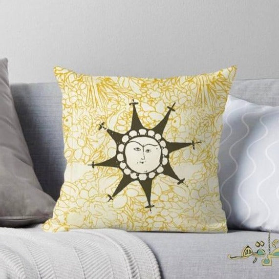 cushion with yellow floral pattern and abstract sun in the center.