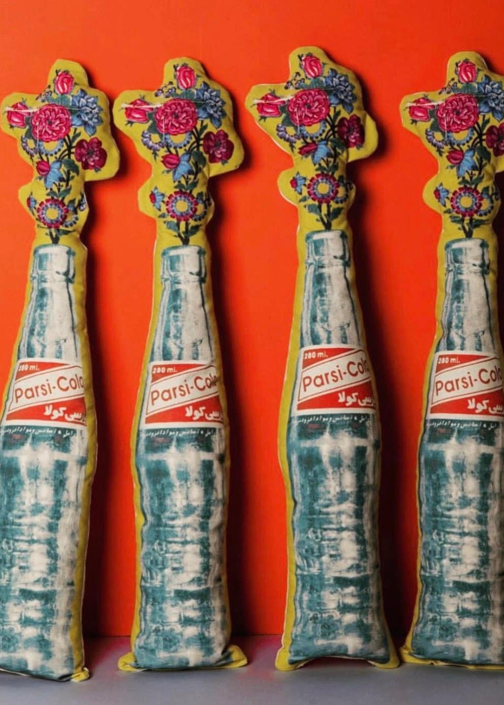 cushion in Parsi Cola shape with flowers on the top.