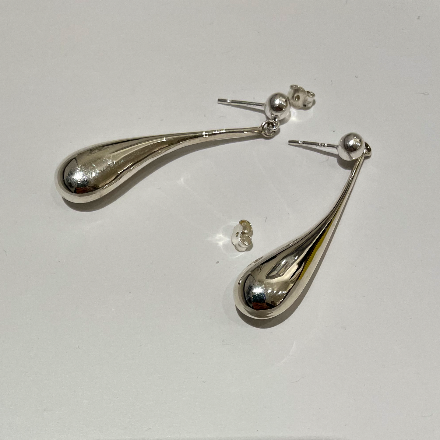 The earrings on a white surface.