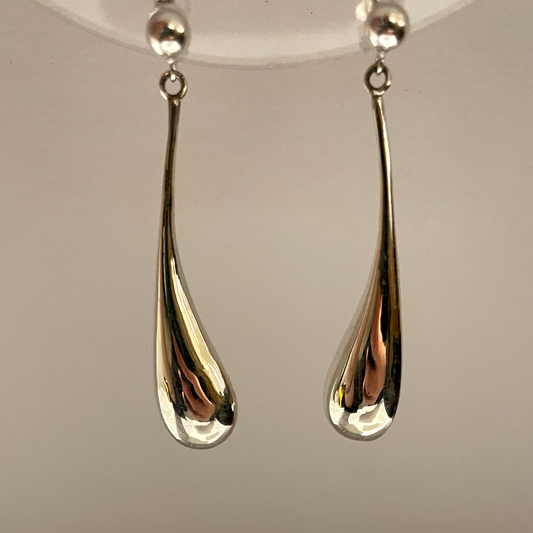 long silver earrings like a blob dropping.