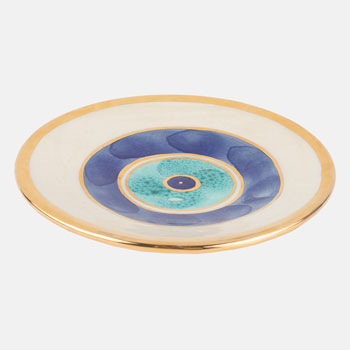 Beige ceramic plate with golden edge and eye design on the center.