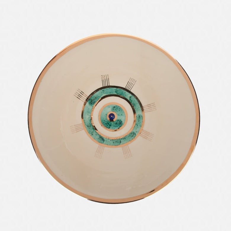 Beige ceramic plate with golden edge and eye design.