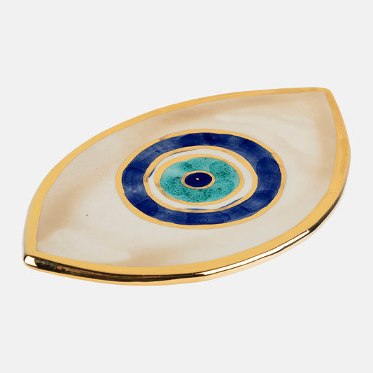 Beige ceramic plate in the shape of eye with golden edge and eye design on the center.