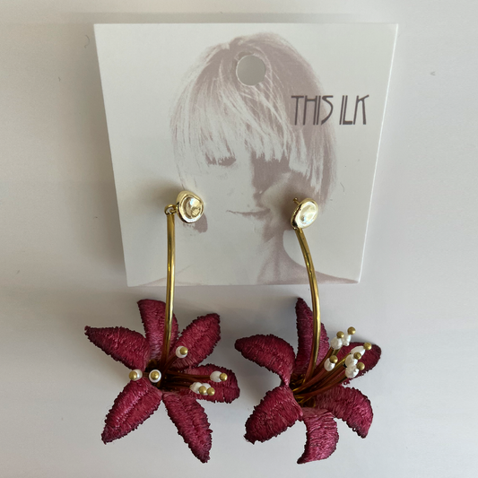 Earings made by Golden color metal and some kind of Textile in dark red color.