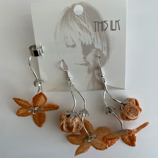 Three Earings made of silver metal and peach color blossoms.
