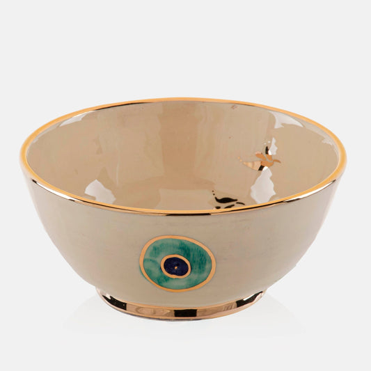 A ceramic bowl with golden edge and Eye design on it.