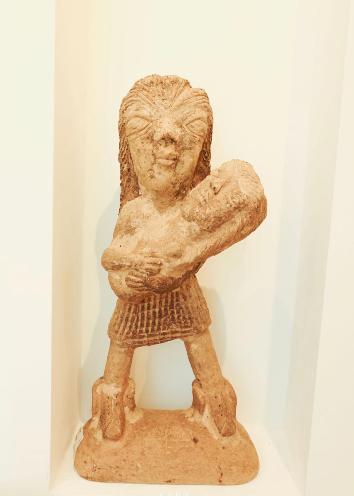 Papier Mache Sculpture; a mother holds her baby in her arms.