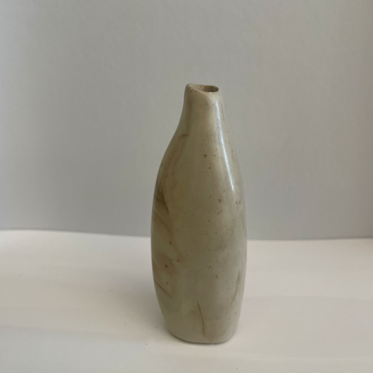 A little beige ceramic vase with asymmetric shape.
