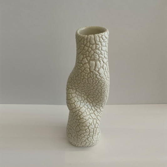 beige vase with cracked glaze and asymmetric shape.