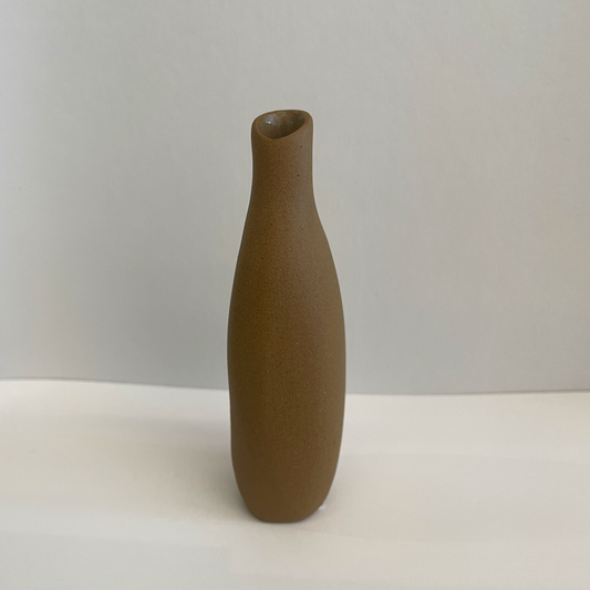 Small brown ceramic vase with asymmetric shape.