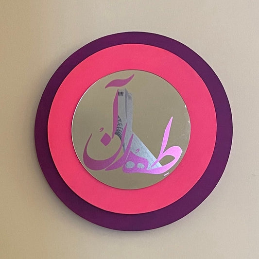 Two concentric wooden circle, the biggest one in purple color and the small one in sharp pink color. and a mirror in smaller size in the center.