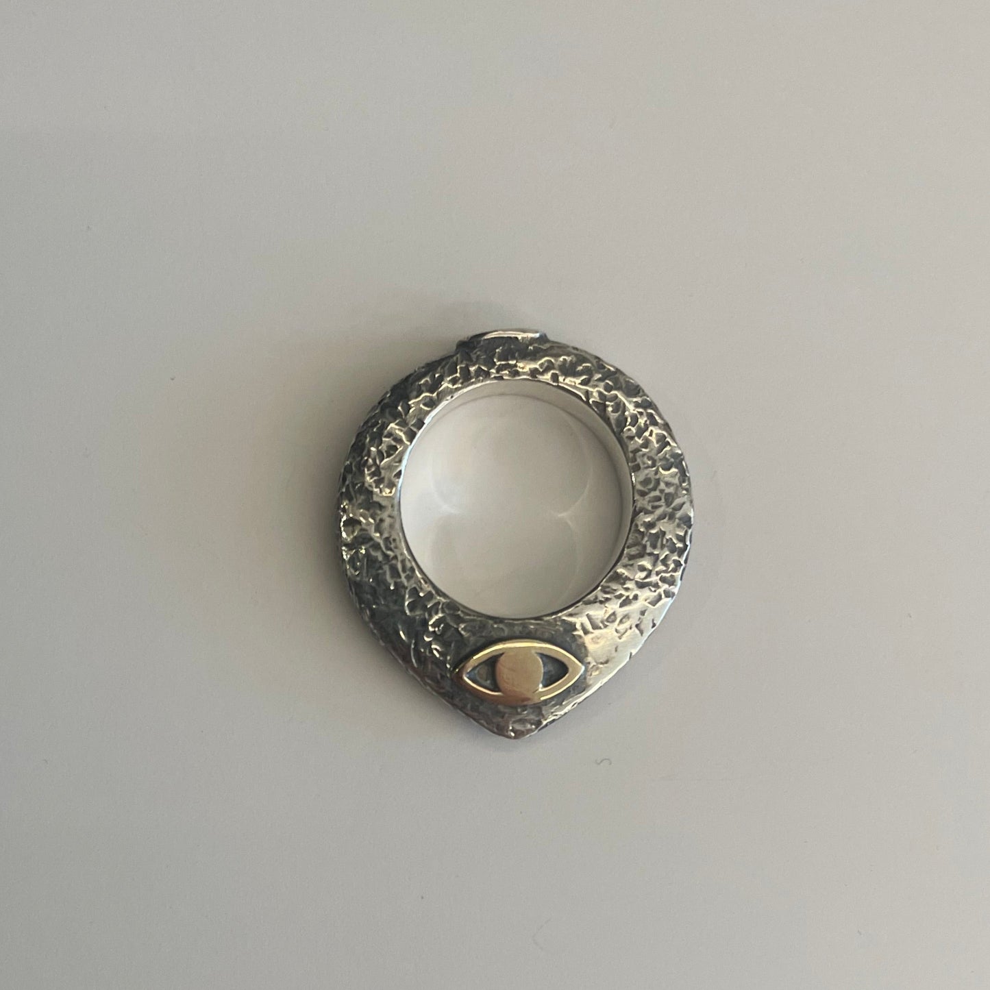 Pointy ring with gold eye on its side.