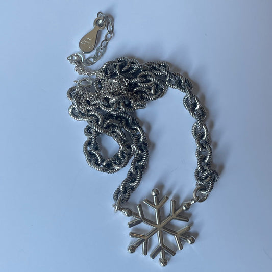 Silver necklace with snow design and thick chain.