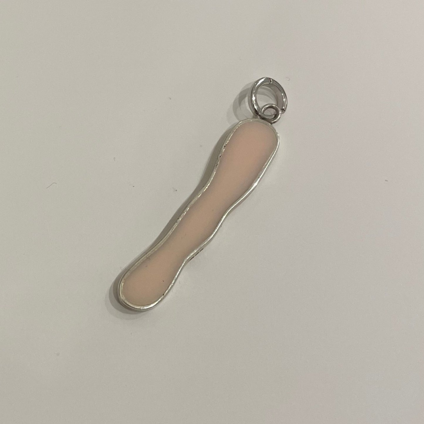 Long irregular shape clip-on charm made by silver and filed by light pink epoxy resin.