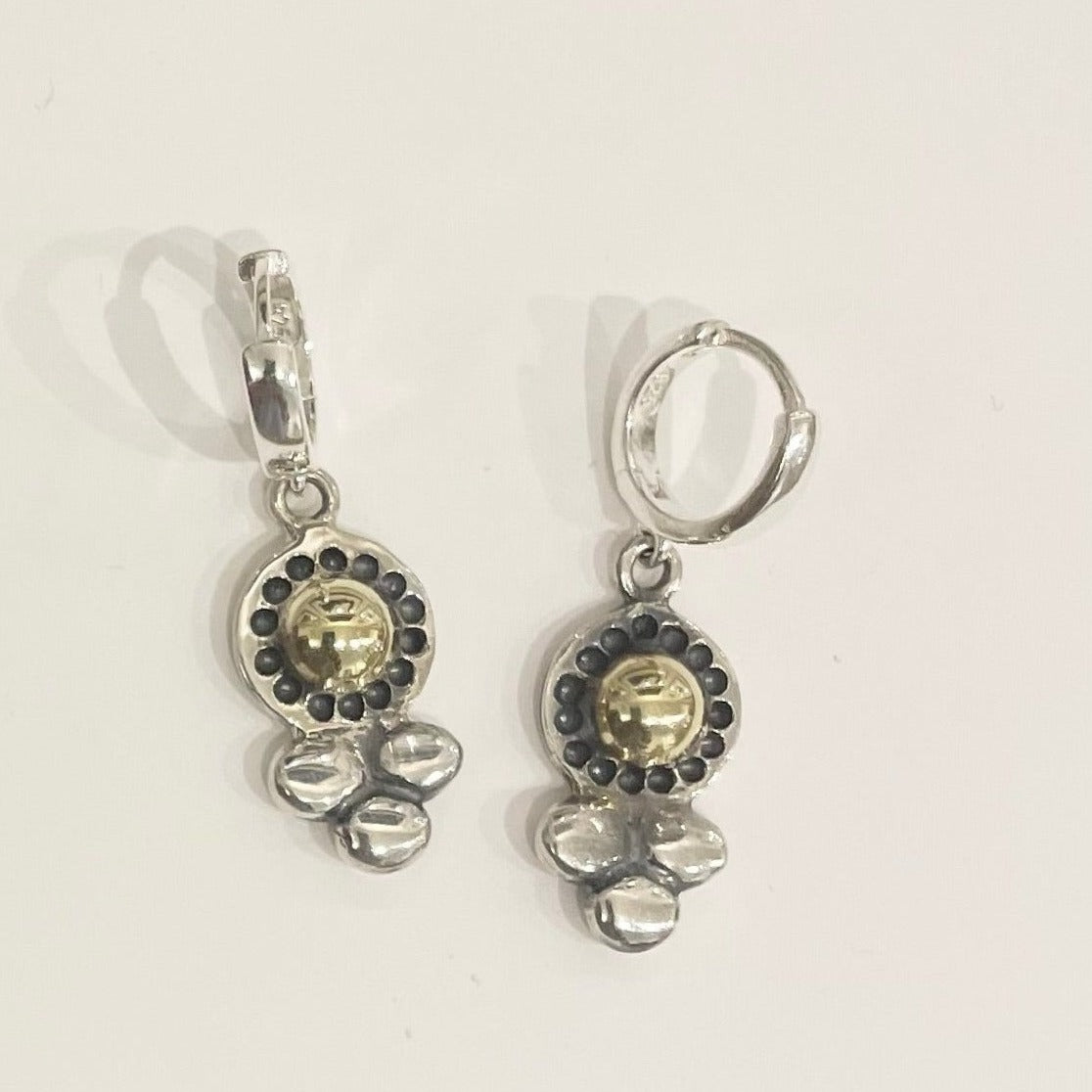 Silver earrings with three silver globe and a gold globe.