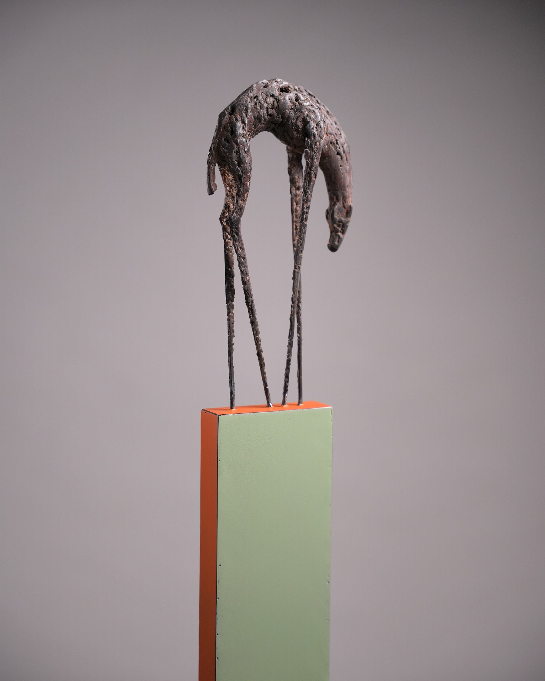 Steel sculpture on a stand; a hunchback animal with long and thin feet.