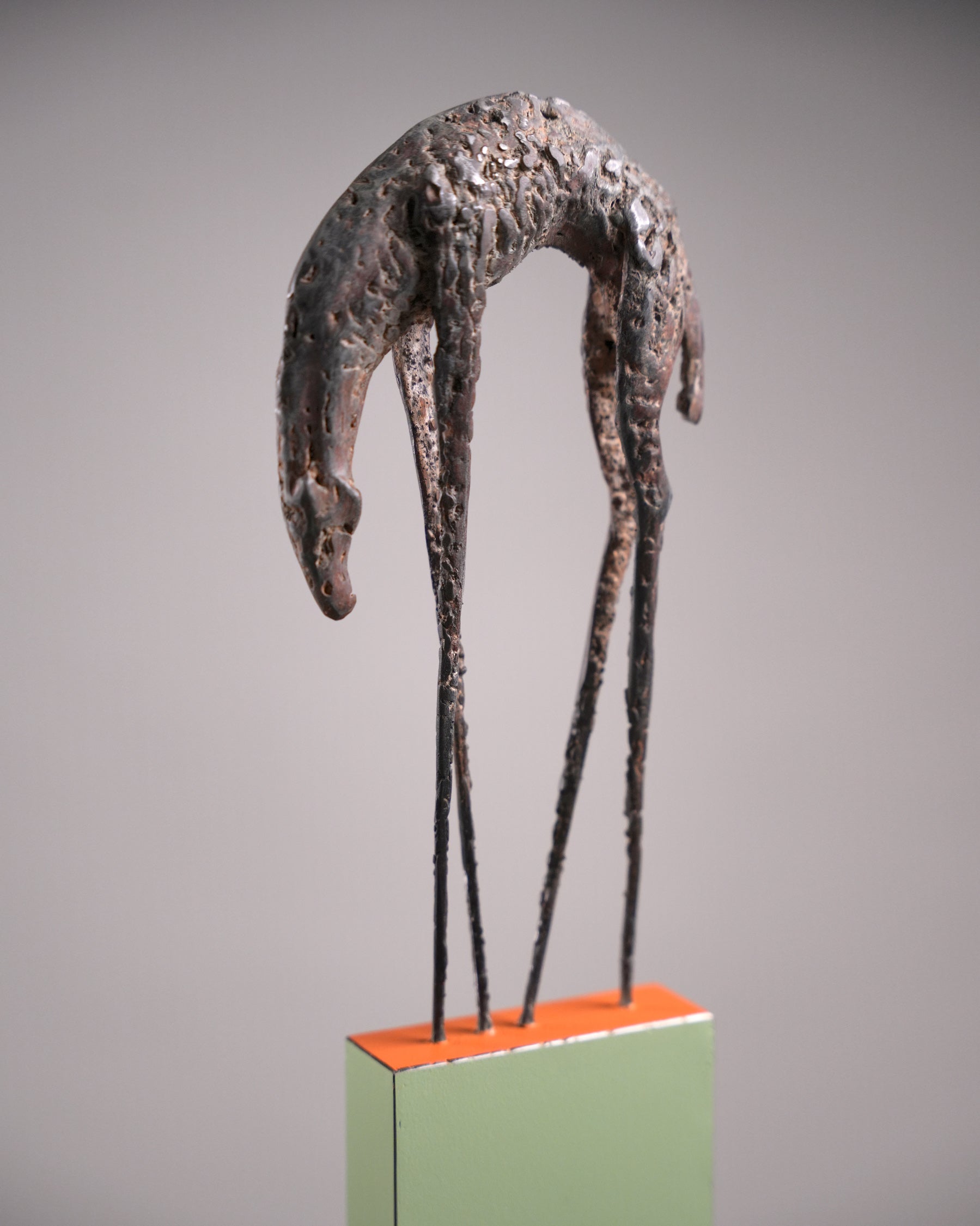 Steel sculpture, a hunchback animal with long and thin feet.