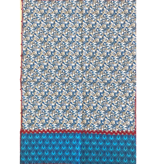 napkin made of two different pattern fabrics but the same tint, and red embroidery on its edge