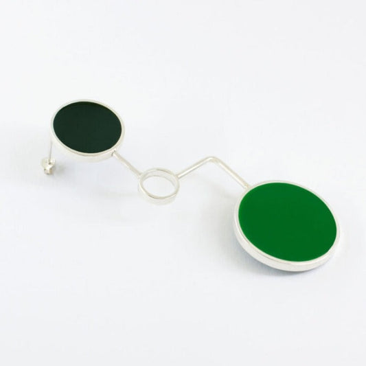 Single earring made of three circle in different size, one of them filled with very dark green epoxy resin and one of them is empty, and the other circle filed with green epoxy resin.