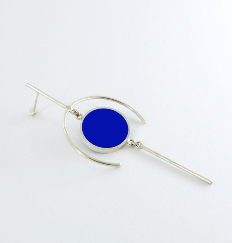 Geometric earring with circle filled with dark blue epoxy resin.