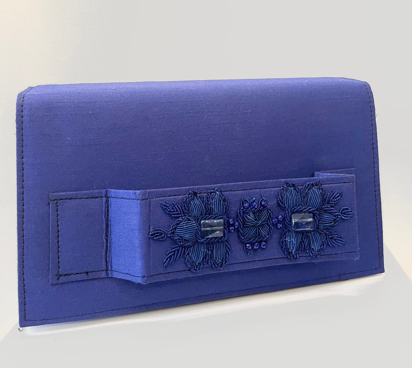 Dark blue clutch with embroidery and beads.