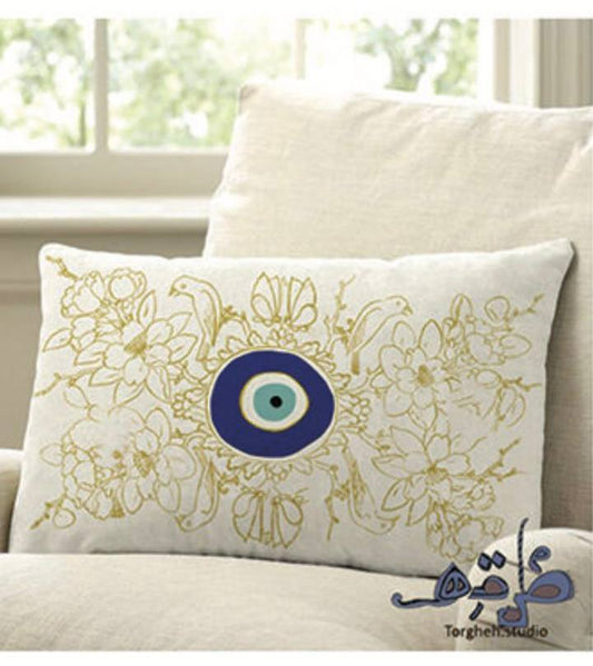 cushion with yellow birds and flowers, and the evil eye in the center.