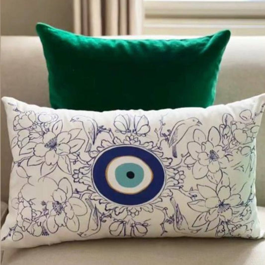 cushion with blue birds and flowers, and the evil eye in the center.