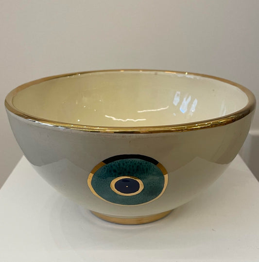 A ceramic bowl with golden edge and Eye design on it.