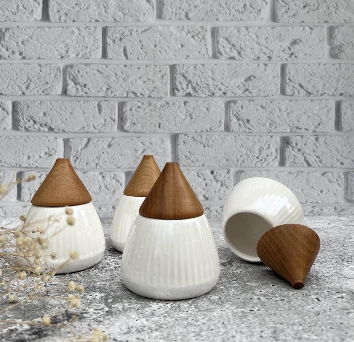 White ceramic bowls with conical shape and wooden lid.